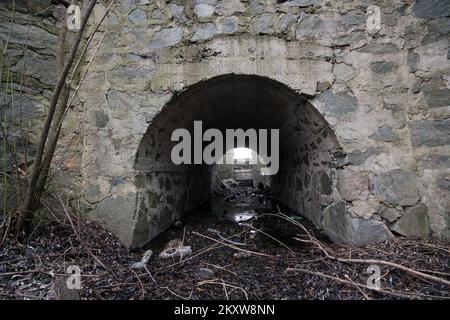 Culvert, drain under road for small river. Concrete culvert is a structure that allows water to flow under a road  from one side to the other side. Stock Photo