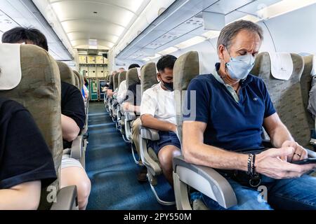 Vietnam Airlines passengers wearing facemasks on flight from Bangkok to Vietnam Stock Photo