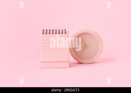 Flip paper calendar for May and alarm clock on pink background Stock Photo