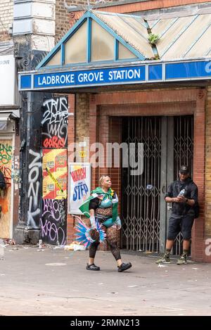 Person in costume passing Ladbroke Grove Station at the Notting Hill Carnival Grand Parade 2023, London, UK. Underground station entrance closed Stock Photo