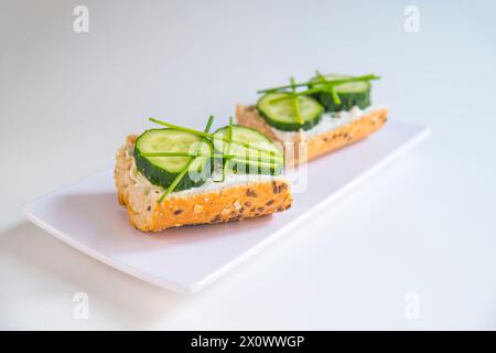 Vegetarian tapa: cucumber and spring onion and cheese cream on toast. Stock Photo