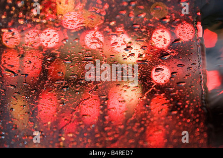 Lights from street cars reflect on a windshield during a rainy day Stock Photo