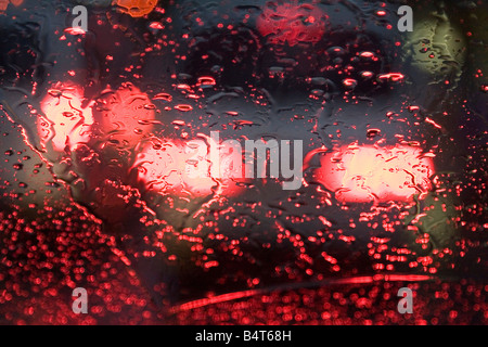 Lights from street cars reflect on a windshield during a rainy day Stock Photo