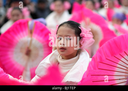 A young girl performing the fan dance at the Chinese New Year parade in the streets of Paris, France Stock Photo