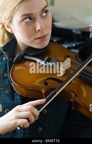 Young woman practicing violin Stock Photo