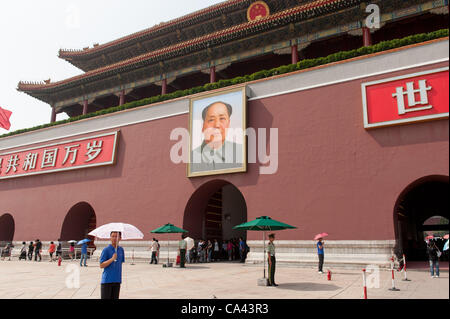 A military guard and plainclothes security officers stand in front of Mao Zedong's portrait on Tiananmen Square, Beijing, China on Monday June 4, 2012. June 4th 2012 marks the 23rd anniversary of the military crackdown on students protests at Tiananmen Square in 1989. Stock Photo