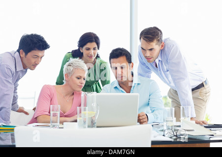 Business people using laptop in meeting Stock Photo