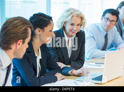 Business people using laptop in meeting Stock Photo