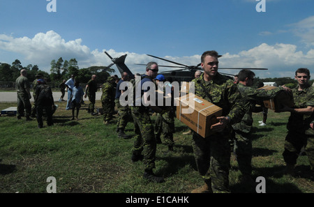 Canadian soldiers, U.S. Sailors and Haitian citizens offload food and water from an MH- 53E Sea Dragon helicopter from Helicopt Stock Photo