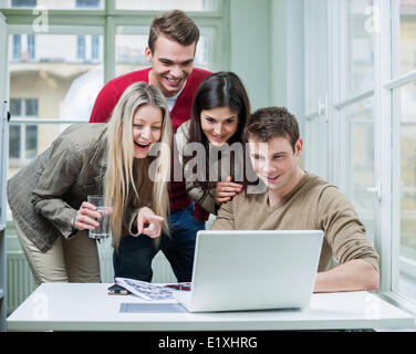 Happy business people using laptop in meeting Stock Photo