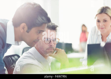 Business people working at computer in sunny office Stock Photo