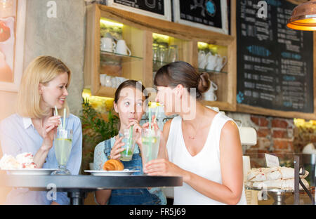 Mother and daughter drinking lemonade at cafe table Stock Photo