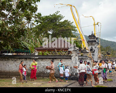 Women wearing traditional Balinese clothing in front of a local temple. Sengkidu village near Candidasa, Karangasem Regency, Bali, Indonesia. Stock Photo