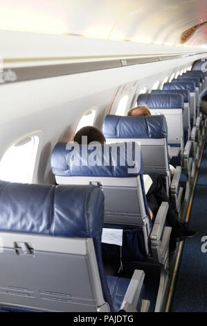 passengers sitting in the economy-class cabin seats of Embraer ERJ-135LR on flight Comandatuba-GRU Stock Photo