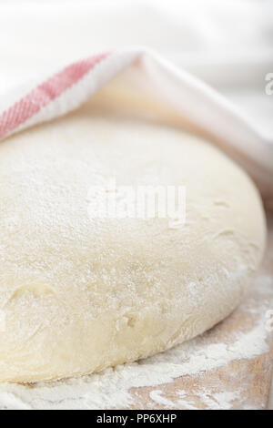 Leavened dough rising on the chopping board Stock Photo