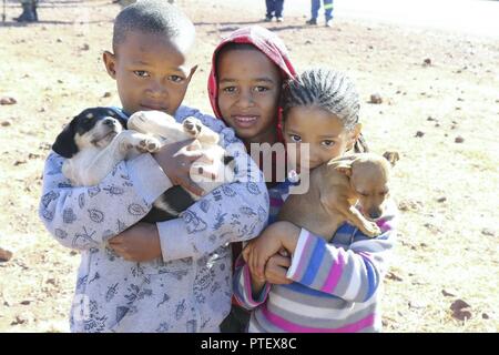 Resident children from the shanty town of Postmasburg, South Africa bring their pets to a free dog clinic July 18 in celebration of Nelson Mandela International Day 2017. U.S. Army Africa Command Stock Photo