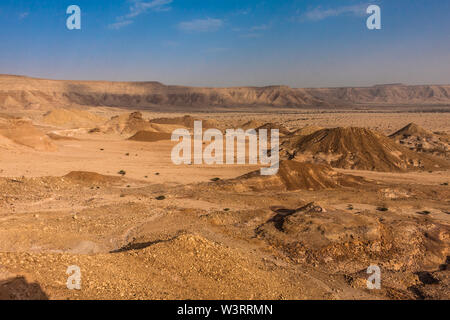 A desert landscape viewed from the Natural Arch of Riyadh. A plain surrounded by the mountain ridge - a Martian-like landscape. Stock Photo