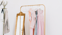 gold clothing rack holding some garments