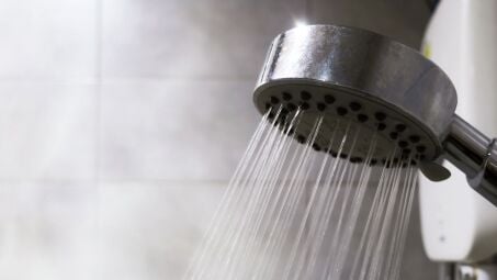 A showerhead spraying water in a steamy shower