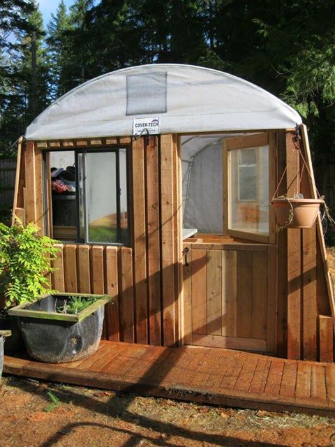 A small wooden shed with a white tarp on top