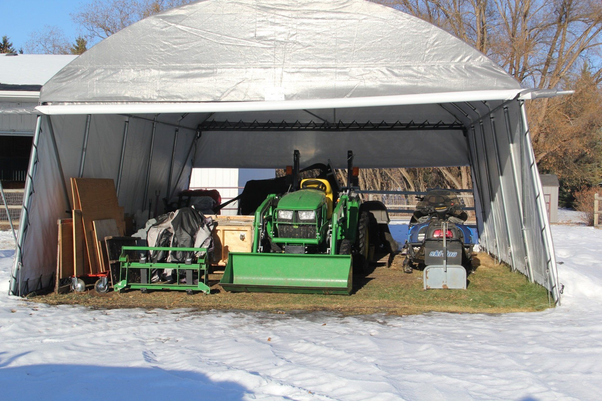 A green john deere tractor is parked in a garage