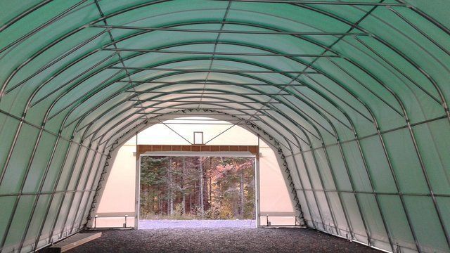 The inside of a green tunnel with a door open.