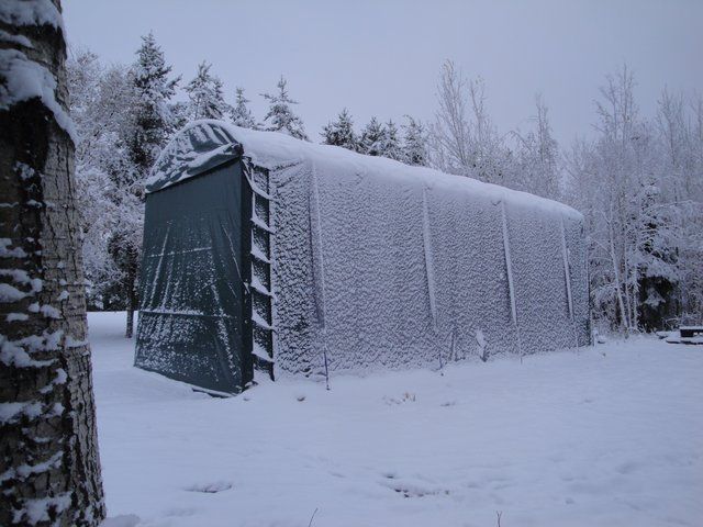 A snow covered building with trees in the background