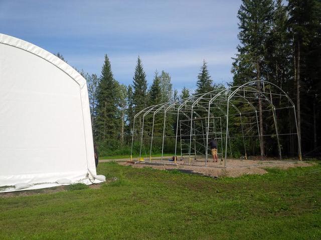 A large white tent is sitting in the middle of a grassy field.