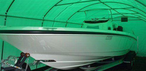 A white boat is sitting inside of a green tent.