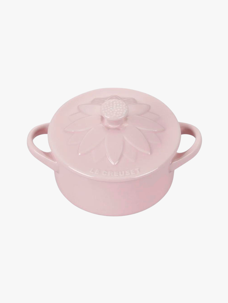 Pink round stoneware cocotte with flower carving on the lid.