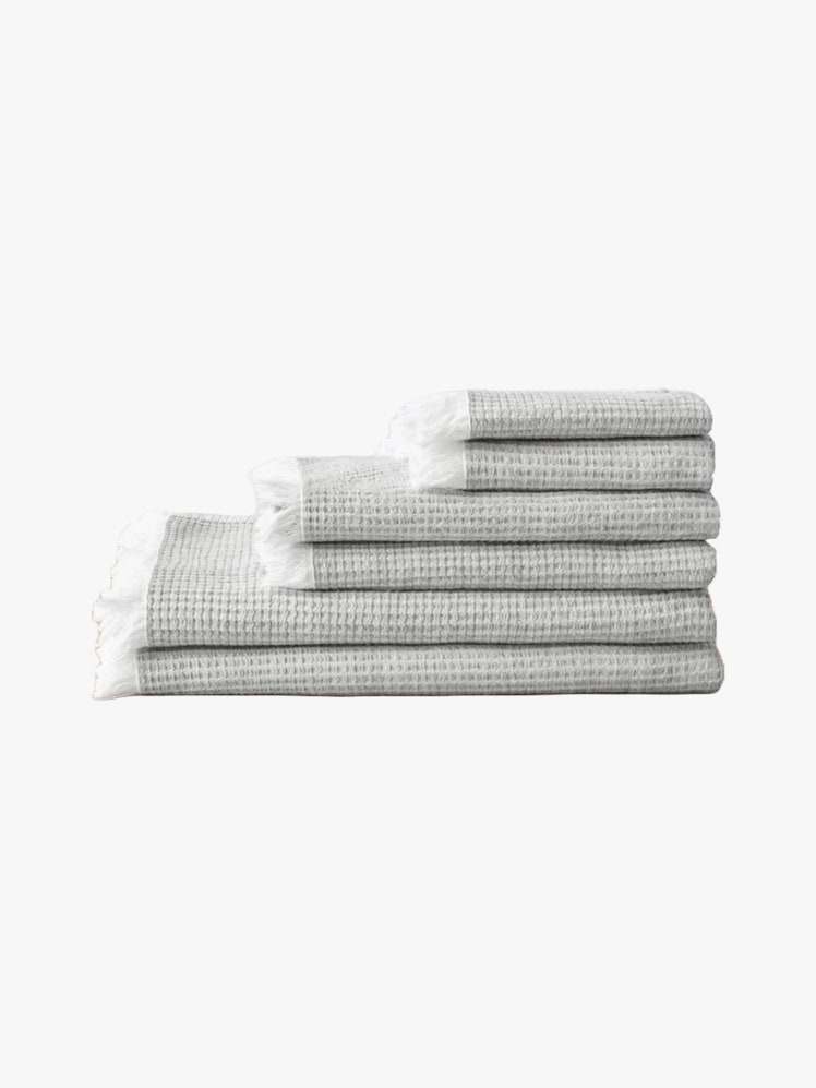 Stack of folded fray cotton and linen towels in various sizes.