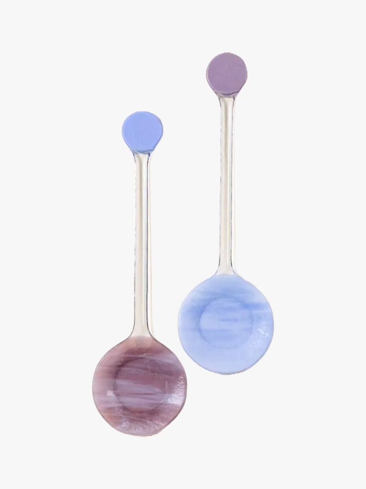 Two glass serving spoons in sky blue and purple.