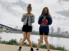 two girls standing next to each other with one wearing a sweater that says love on it