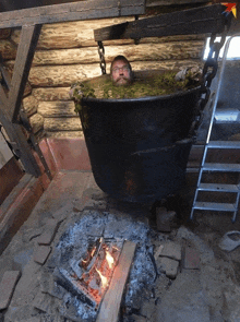 a man is sitting in a large pot of water with his head in it