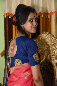 a woman wearing a blue blouse with gold embroidery