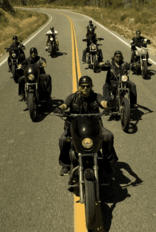 a group of men are riding motorcycles on a highway