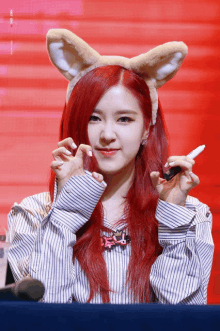 a woman with red hair wearing a headband with ears