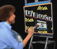 bob ross is painting a sign that says batman suck