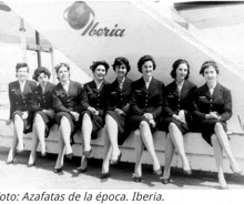 a black and white photo of a group of women sitting in front of an iberia plane