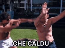 two shirtless men are fighting with the words che caldu in the upper right corner