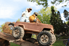 two stuffed animals are sitting in a toy jeep with a tire that says bridgestone