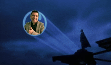 a man giving a thumbs up in a circle with a batman logo in the background