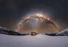 a house in the middle of a snowy field with the milky way visible