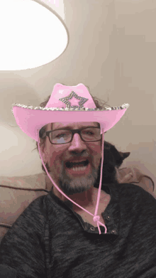 a man is wearing a pink cowboy hat with a star on it