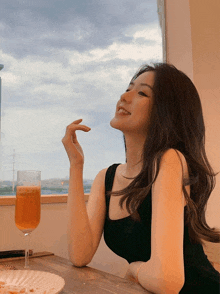 a woman sits at a table with a glass of wine