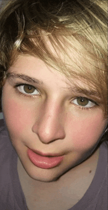 a close up of a young man 's face with a pink lip