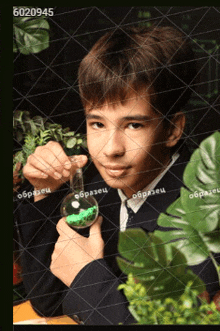 a boy is holding a beaker with green liquid in it and the number 602095 on the bottom right