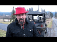 a man wearing a red hat and a black jacket is standing in front of a buggy .