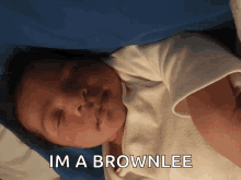 a baby laying down with the words im a brownlee above it