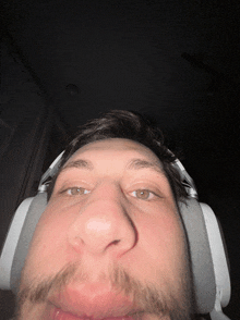 a man with a beard wearing headphones makes a funny face